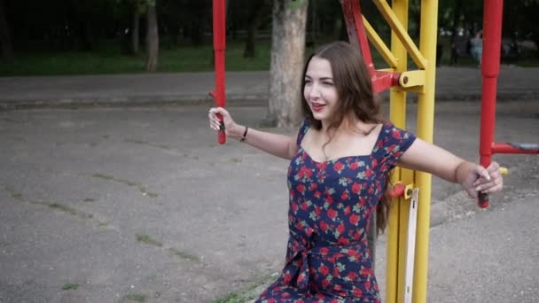Νεαρή γυναίκα χαμογελά και προσπαθεί να λειτουργήσει έξω στο δρόμο προσομοιωτές Πάρκο — Αρχείο Βίντεο