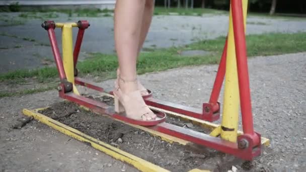 Κοντινά πόδια σε τακούνια παπούτσια επιχειρηματίας σε μηχανήματα άσκησης στο πάρκο της πόλης — Αρχείο Βίντεο