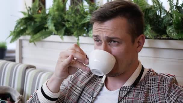 Close up portrait man in cafe talking to someone and drinking tea or coffee — Stock Video