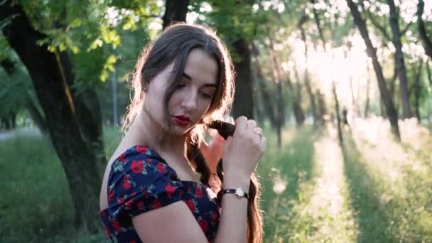 Jeune belle jolie femme se déroule tresse de cheveux longs sur la rue dans le parc — Video