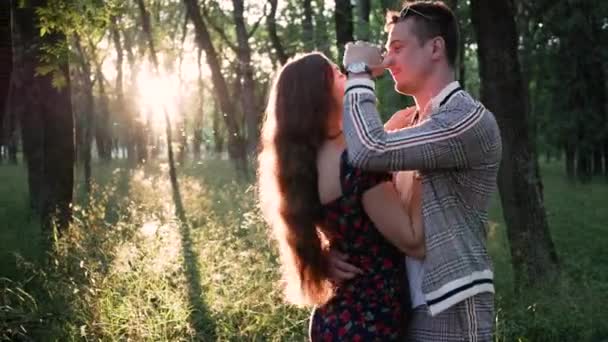 Felice e gioioso giovane uomo e donna abbraccio nel parco in estate al tramonto — Video Stock