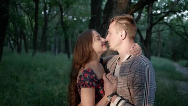 Joyful man and woman having fun together in park. They hug, smile and kiss — Stock Video