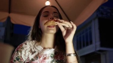 Genç ve güzel bir kadın pizza yiyor. Beyaz kadın elinde pizza dilimi tutuyor. İştah açıyor.