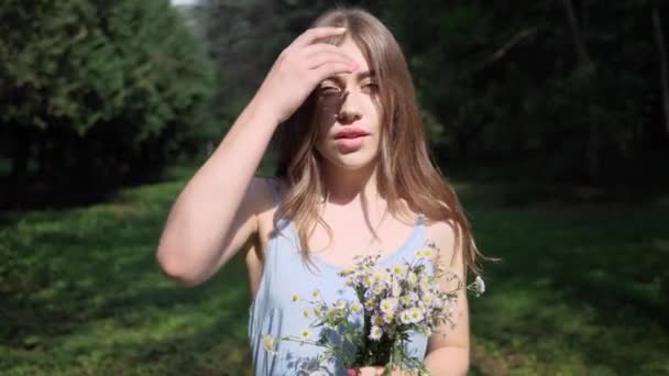 Porträt sexy Frau mit Blumenstrauß im Freien im Park, Glättung der Haare — Stockvideo