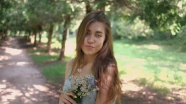 Papatyalı kadın yazın güçlü ve parlak saçlarını Park 'ta gösteriyor.