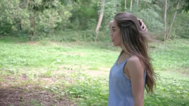 Mulher com buquê de margaridas mostra seu cabelo forte e brilhante no verão no parque — Vídeo de Stock