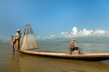 Inle Gölü, Myanmar - Kasım 2013 yaklaşık: Birmanya adam küçük bir tekne Inle gölde kürek. Inle yerliler kendi benzersiz bacak tekniği kürek için ünlü.