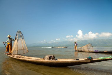 Inle Gölü, Myanmar - Kasım 2013 yaklaşık: Birmanya adam küçük bir tekne Inle gölde kürek. Inle yerliler kendi benzersiz bacak tekniği kürek için ünlü.