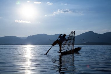 Inle Gölü, Myanmar - Kasım 2013 yaklaşık: Birmanya adam küçük bir tekne Inle gölde kürek. Inle yerliler kendi benzersiz bacak tekniği kürek için ünlü.
