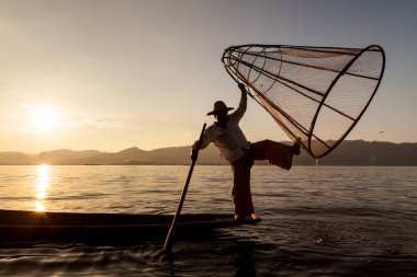 Inle Gölü, Myanmar - Kasım 2013 yaklaşık: Birmanya adam küçük bir tekne Inle gölde kürek. Inle yerliler kendi benzersiz bacak tekniği kürek için ünlü.
