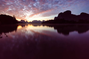 İlk ışıklarıyla şafak sakin bir göl üzerinde.