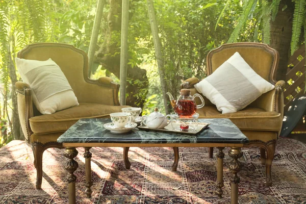 Herbal tea in crystal pot in the garden.