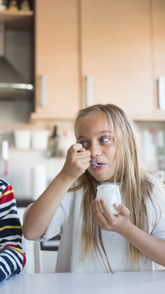 Happy children eating a yogurt. — Stock Photo, Image