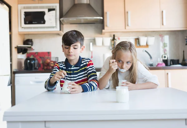 Glückliche Kinder essen einen Joghurt. — Stockfoto