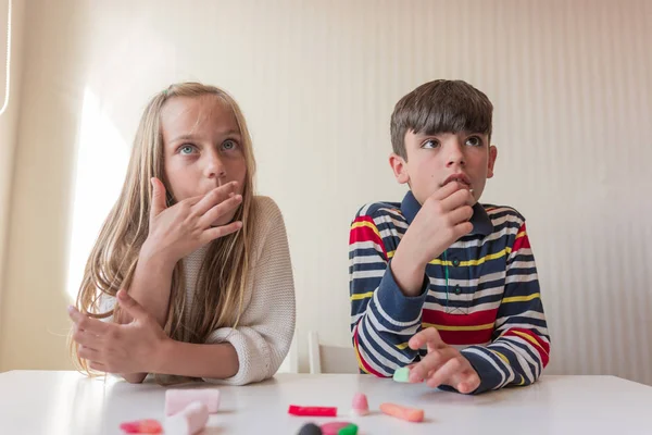 ダイニングテーブルでお菓子を食べる子供たち — ストック写真