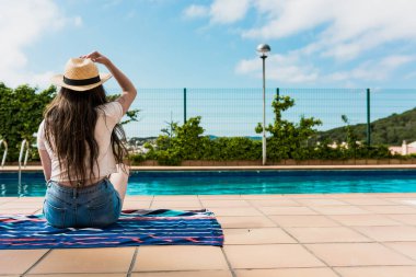 Evinde havuz başında güneşlenen kız