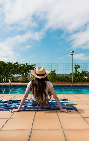 Menina tomando banho de sol junto à piscina em sua casa — Fotografia de Stock