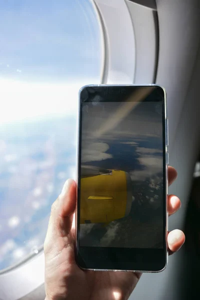 Smartphone tomando fotos desde la ventana del avión , —  Fotos de Stock