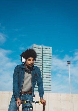 Afro saçlı adam bir vintage tarzı bisiklet sürme 