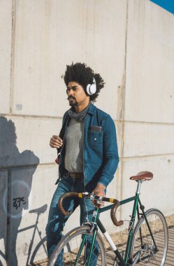 Afro saçlı adam bir vintage tarzı bisiklet sürme 