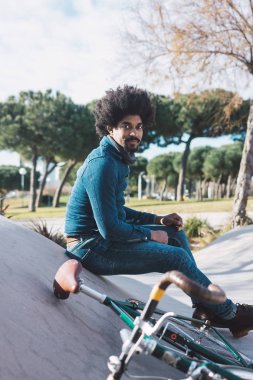 Afro saçlı adam bir vintage tarzı bisiklet sürme 