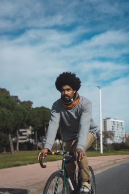 Afro saçlı adam bir vintage tarzı bisiklet sürme 