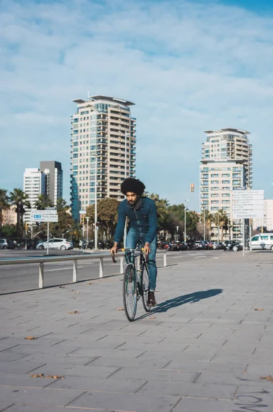 Hombre con pelo afro montando una bicicleta de estilo vintage — Foto de Stock