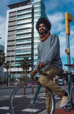 Afro saçlı adam bir vintage tarzı bisiklet sürme 