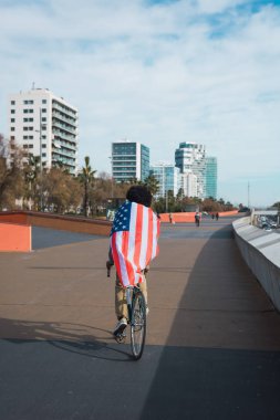 Afro saçlı adam gururla Amerikan bayrağını gösteriyor 