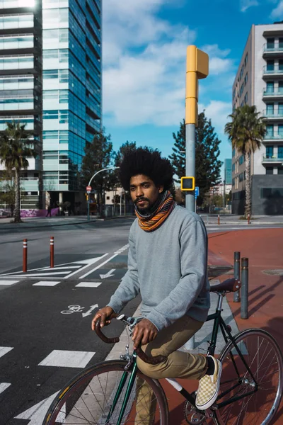 Hombre con pelo afro montando una bicicleta de estilo vintage — Foto de Stock