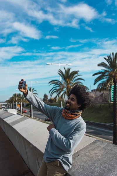 Portrait d'homme noir aux cheveux afro en regardant son smartp — Photo