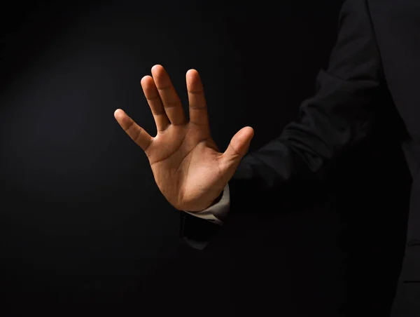 Geschäftsmann die Hand auf schwarzem Hintergrund — Stockfoto