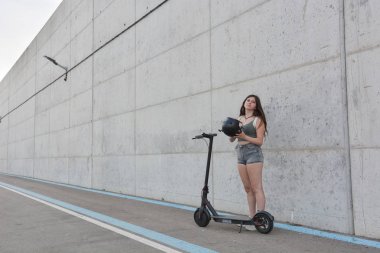 Teenage girl circulating with an electric scooter clipart