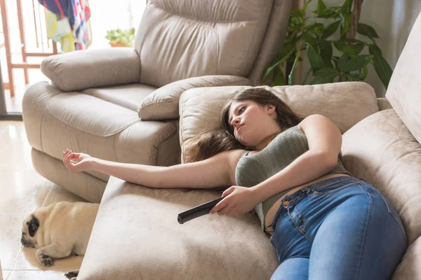 Girl lying on the couch of her house watching TV — Stock Photo, Image
