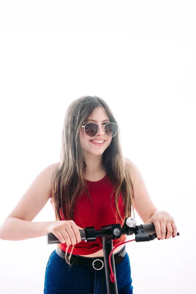 Ragazza alla guida di uno scooter elettrico con una faccia di velocità . — Foto Stock