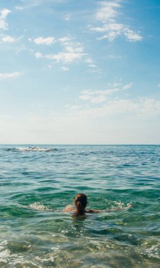 40 yaşında bir kadın kumsalda güneşli bir yaz gününün tadını çıkarıyor. Denizde ferahlatıcı bir yüzüş yapacağım.