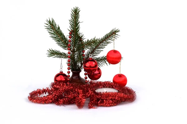 çam dalları ile beyaz zemin üzerine kırmızı Noel süsleri