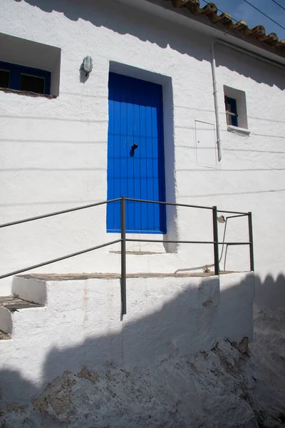 Beyaz duvardaki mavi kapı iyi korunmuş.