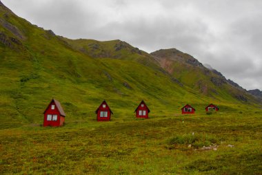 Terk edilmiş kırmızı kabin yeşil yemyeşil dağlar Alaska s Hatcher Pass bağımsızlık benim, Amerika Birleşik Devletleri yanında oturmak