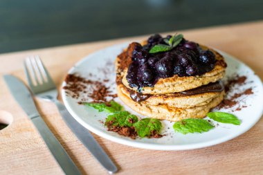 Lezzetli yulaf ezmesi, ev yapımı çikolatalı krep, pişmiş yabanmersini ve taze nane yaprağı. Sağlıklı yemek pişirme