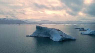 İzlanda 'daki Glacier Lagoon Jokulsarlon' un renkli günbatımı ışıklarında çekilmiş yüksek kaliteli 4K görüntüleri. Buzdağlarıyla dolu göl İzlanda 'da ziyaret edilecek en manzaralı yerlerden biridir.