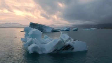 İzlanda 'daki Glacier Lagoon Jokulsarlon' un renkli günbatımı ışıklarında çekilmiş yüksek kaliteli 4K görüntüleri. Buzdağlarıyla dolu göl İzlanda 'da ziyaret edilecek en manzaralı yerlerden biridir.
