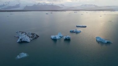 İzlanda 'daki Glacier Lagoon Jokulsarlon' un renkli günbatımı ışıklarında çekilmiş yüksek kaliteli 4K görüntüleri. Buzdağlarıyla dolu göl İzlanda 'da ziyaret edilecek en manzaralı yerlerden biridir.