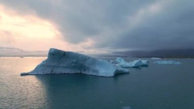 İzlanda 'daki Glacier Lagoon Jokulsarlon' un renkli günbatımı ışıklarında çekilmiş yüksek kaliteli 4K görüntüleri. Buzdağlarıyla dolu göl İzlanda 'da ziyaret edilecek en manzaralı yerlerden biridir.
