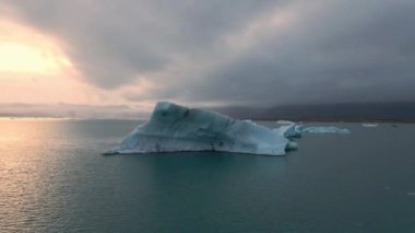 İzlanda 'daki Glacier Lagoon Jokulsarlon' un renkli günbatımı ışıklarında çekilmiş yüksek kaliteli 4K görüntüleri. Buzdağlarıyla dolu göl İzlanda 'da ziyaret edilecek en manzaralı yerlerden biridir.