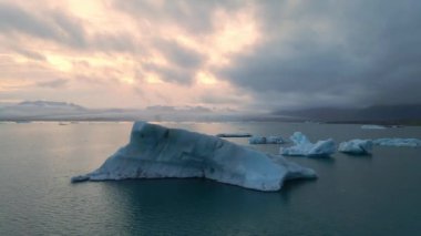 İzlanda 'daki Glacier Lagoon Jokulsarlon' un renkli günbatımı ışıklarında çekilmiş yüksek kaliteli 4K görüntüleri. Buzdağlarıyla dolu göl İzlanda 'da ziyaret edilecek en manzaralı yerlerden biridir.