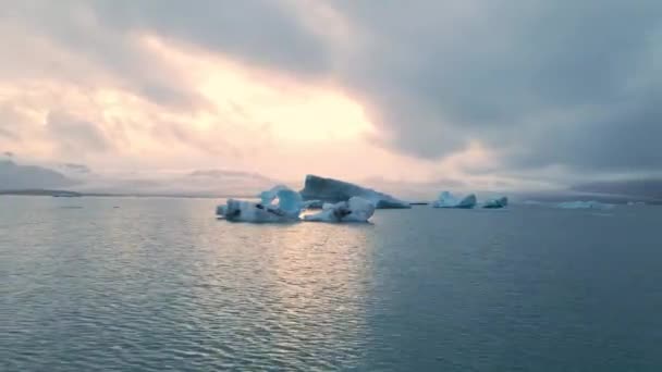 Une vidéo 4K de haute qualité de la lagune du glacier Jokulsarlon en Islande pendant l'heure d'or aux lumières colorées du coucher du soleil. Lagon plein d'icebergs est l'un des endroits les plus pittoresques à visiter en Islande
