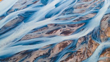 Yukarıdan bir buzul nehri. Nehrin havadan çekilmiş fotoğrafı İzlanda buzullarından geliyor. İzlanda 'da yaratılan doğa ananın güzel sanatı. Duvar kağıdı arka plan yüksek kaliteli fotoğraf