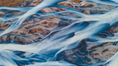 Yukarıdan bir buzul nehri. Nehrin havadan çekilmiş fotoğrafı İzlanda buzullarından geliyor. İzlanda 'da yaratılan doğa ananın güzel sanatı. Duvar kağıdı arka plan yüksek kaliteli fotoğraf