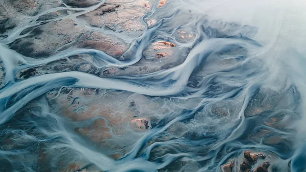 Yukarıdan bir buzul nehri. Nehrin havadan çekilmiş fotoğrafı İzlanda buzullarından geliyor. İzlanda 'da yaratılan doğa ananın güzel sanatı. Duvar kağıdı arka plan yüksek kaliteli fotoğraf
